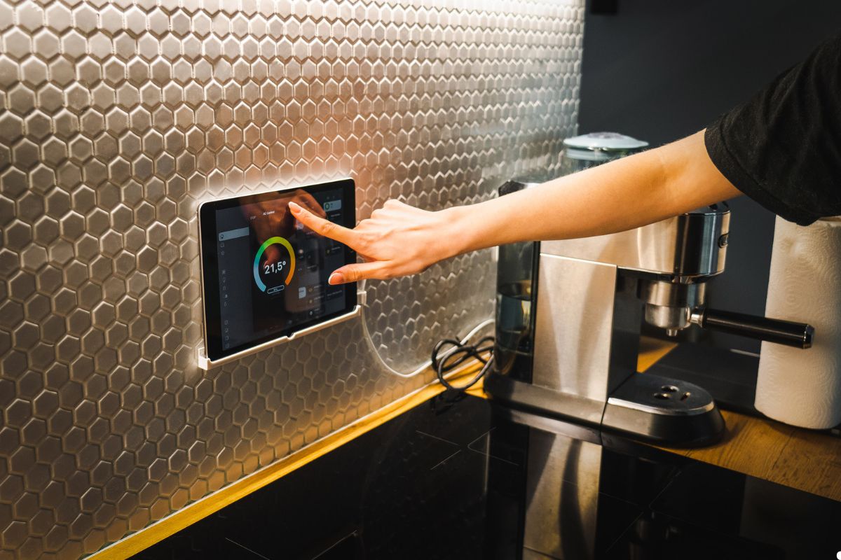 A person interacting with a tablet placed on a countertop, focusing on the screen with their finger. 