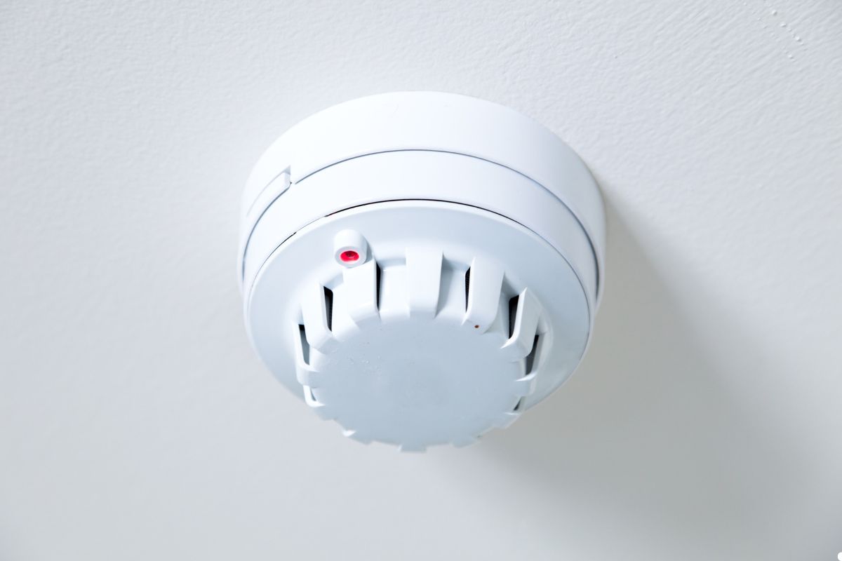 White smoke detector installed on a wall, designed for fire safety and early smoke detection in residential spaces. 